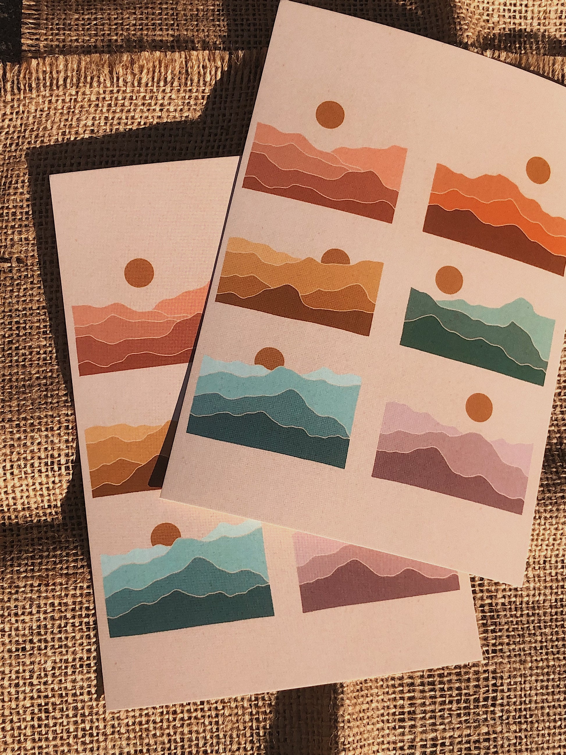Picture of two rainbow mountain prints in direct sunlight over two pieces of burlap fabric.