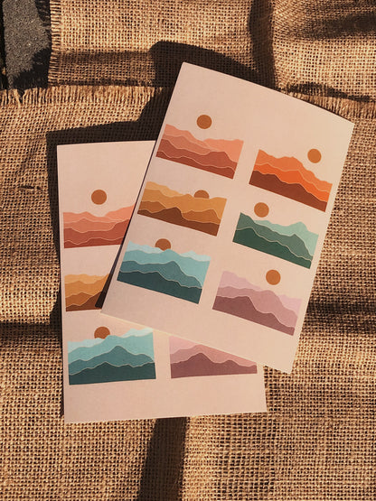 Picture of two rainbow mountain prints in direct sunlight over two pieces of burlap fabric.