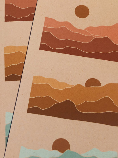 Close-up picture of two rainbow mountain prints in direct sunlight over two pieces of burlap fabric.